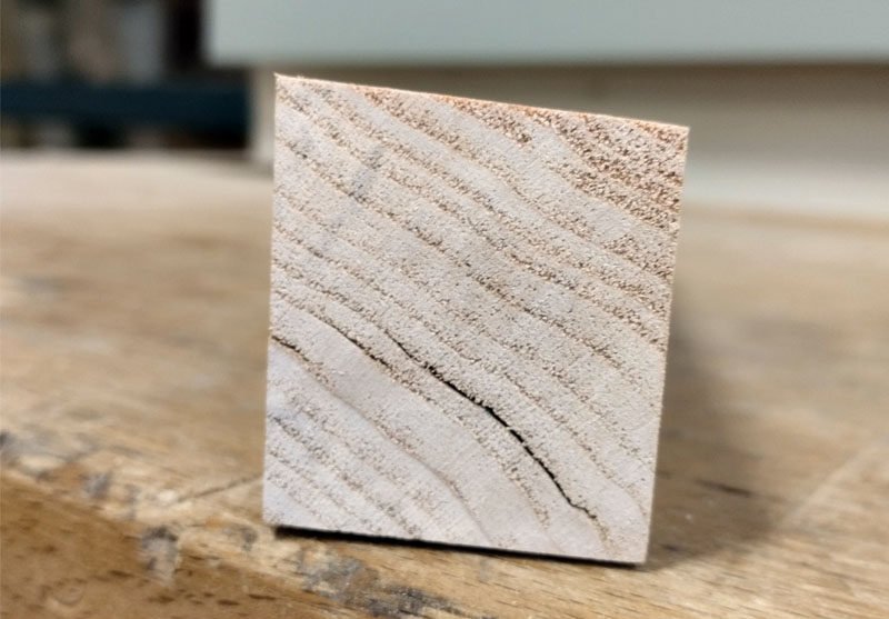 Pièce de bois destinée à la butée de rabotage montrant un léger biais sur la face supérieure.