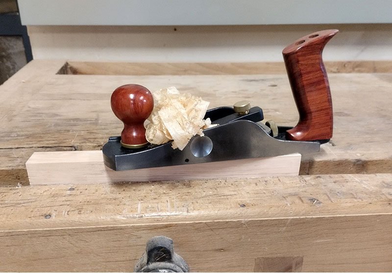 Dressage de la face supérieure de la pièce serrée dans la presse d’établi avec un rabot à replanir.