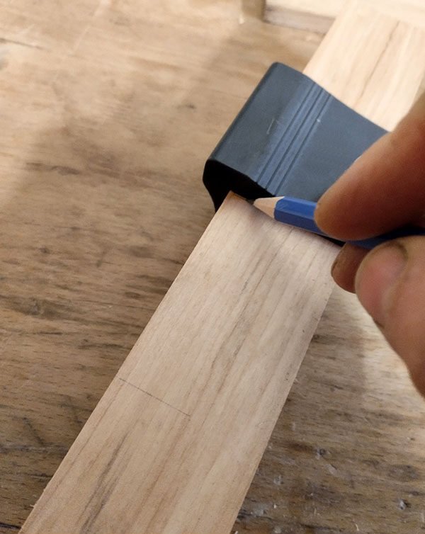 Report du tracé grâce à une équerre de renvoi sur les faces adjacentes de la pièce