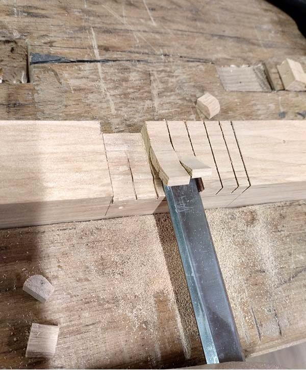 Retrait du bois de l’entaille avec un ciseau sur la pièce serrée dans la presse.