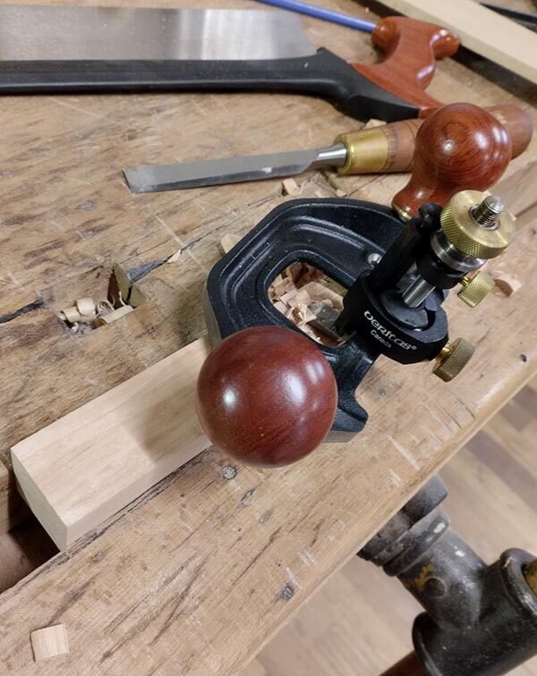 Finition de l’entaille avec une guimbarde sur la pièce serrée dans la presse.