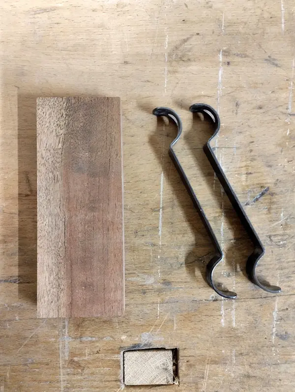 Bloc de bois posé sur un établi avec, à côté, les deux outils à arrondir Veritas vus de dessus, utilisés pour réaliser des essais d’arrondis.