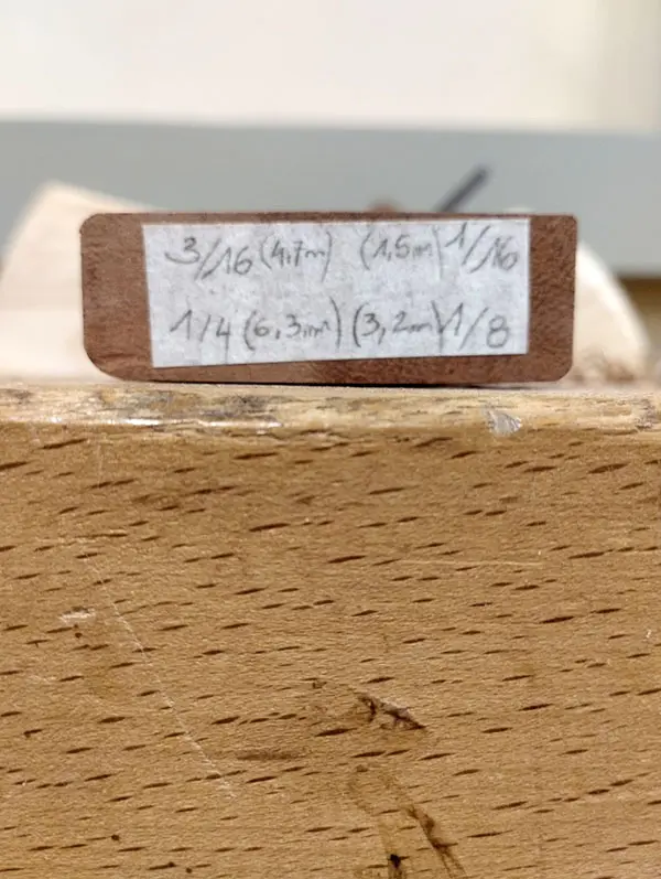 Bloc de bois posé sur l’établi, photographié au ras du plateau, montrant les quatre arêtes arrondies avec des rayons différents réalisés à l’aide des outils Veritas.